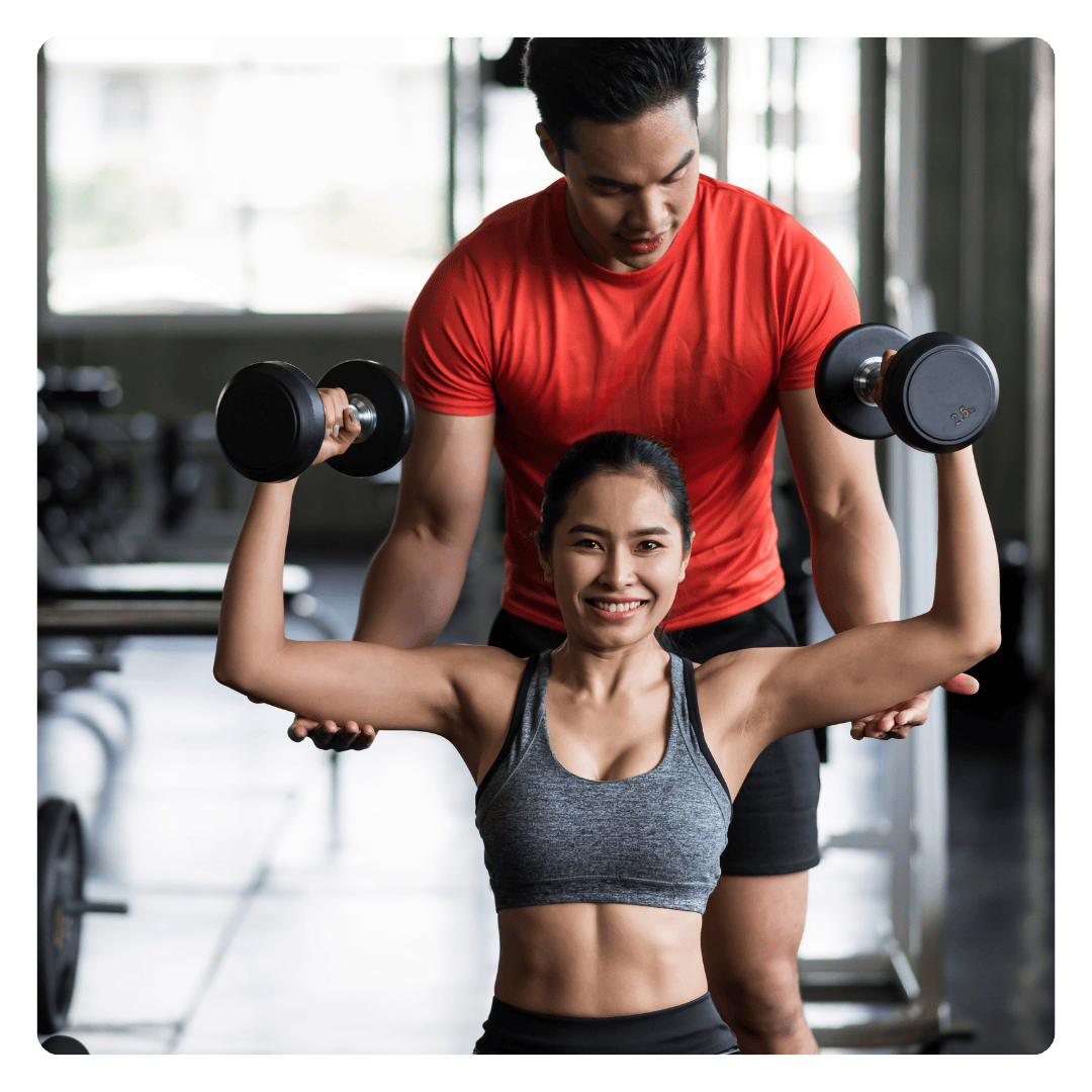 Trainer helping client do dumbbell press